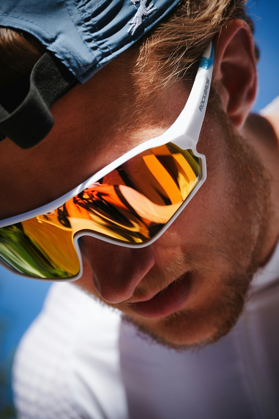 Technical wraparound sport sunglasses for sailing on a dark surface