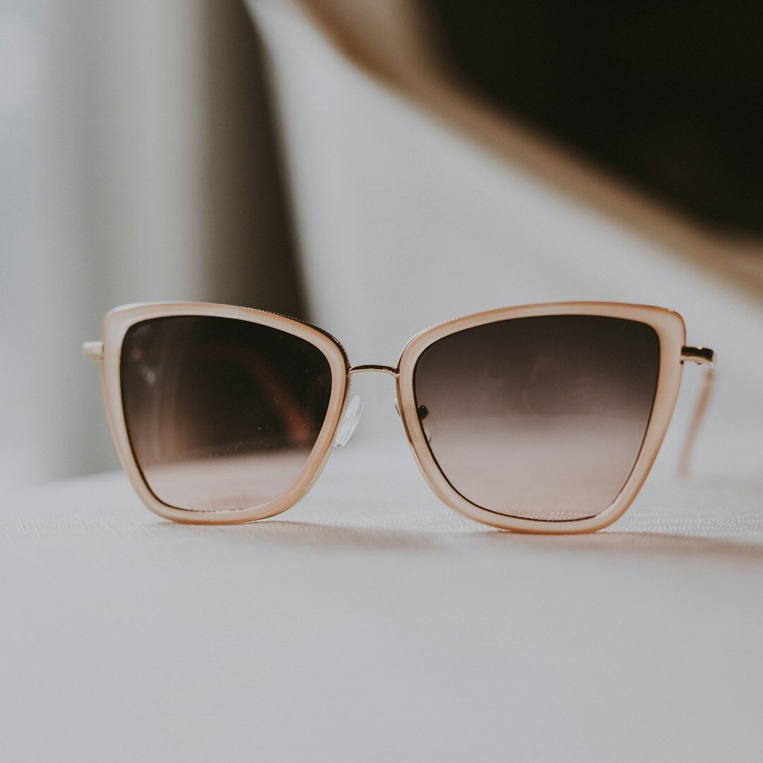Designer sunglasses with bold acetate frame on a neutral background