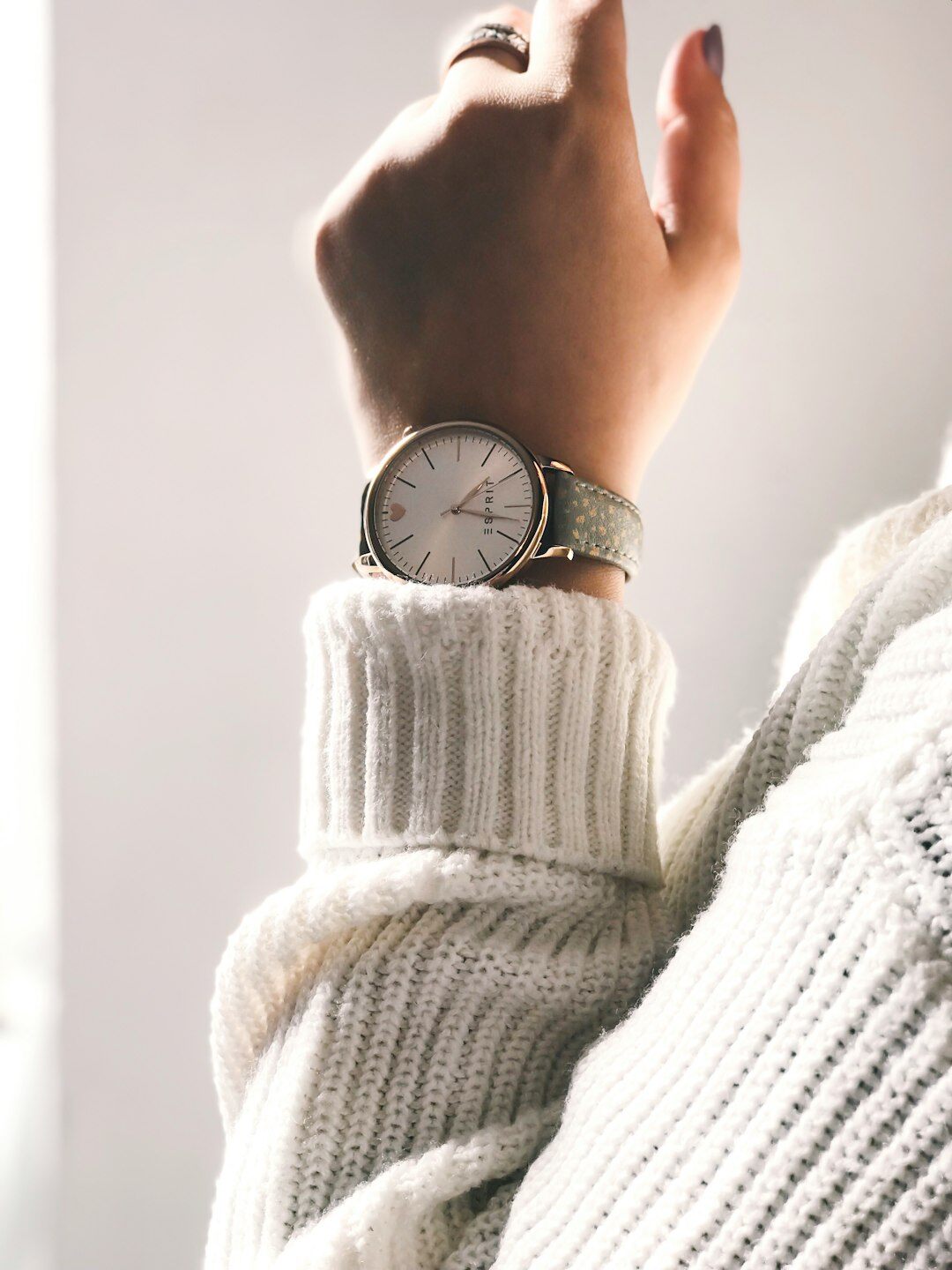 Slim gold dress watch with leather strap on a marble surface