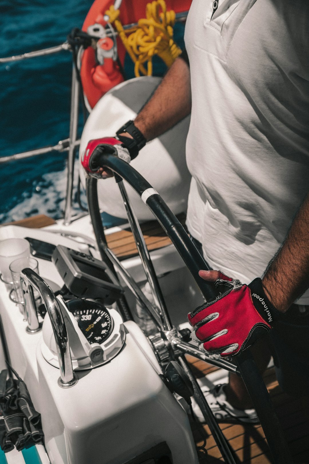 Luxury diving chronograph watch on a sailor's wrist aboard a yacht